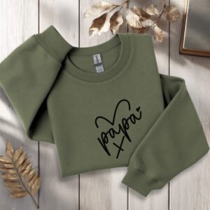crewneck papa brodé avec cœur posé sur fond décoratif